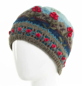 Colorful wool beanie features a mountain scene over-stitched with raised floral embroidery