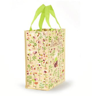 Beige tote bag with lime green handles features all-over flower illustrations with a central kneeling gardener picking one of them under the words, "Dirt Bag"