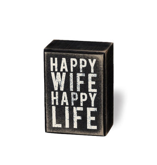 Rectangular black box sign with distressed finish says, "Happy wife happy life" in large white lettering