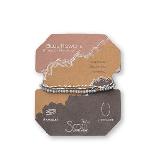 Blue howlite and silver beaded bracelet/necklace wrapped around product card with gold foil design details