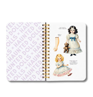Page spread from Haunted Dolls: A Sticker Book features one graphically printed page, double gold wire binding, and another page of illustrated creepy dolls and doll parts with captions