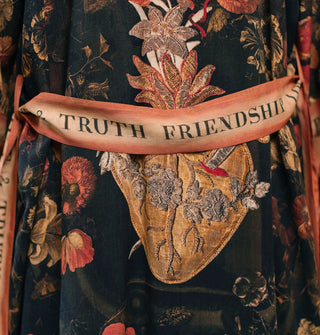 Dark robe with pierced heart design and contrasting belt that says, "Friendship, Love & Truth"