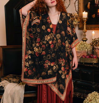 Model wears a black robe with floral print and contrasting border that says, "Friendship, Love & Truth"