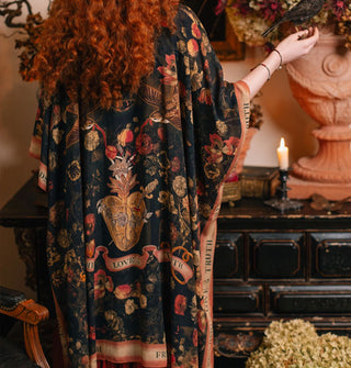 Model wears a black robe with floral print and contrasting border that says, "Friendship, Love & Truth"