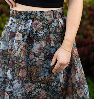 Closeup of a skirt's waistband with gathered pleats and floral print fabric