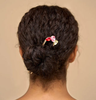 Model wears a tri-color rhinestone-accented gold French hair pin in a low chignon