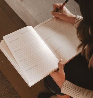 Model writes in a lined, prompted Holiday Memories journal