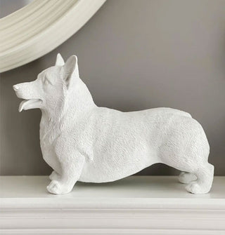 White corgi sculpture on a mantel against a gray wall