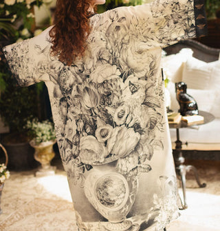 Model facing away from the camera wears a lightweight robe with black and white floral vase design