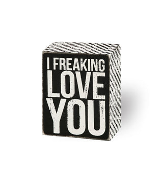 Rectangular black and white box sign says, "I freaking love you" on the front and features a zigzag pattern along the sides
