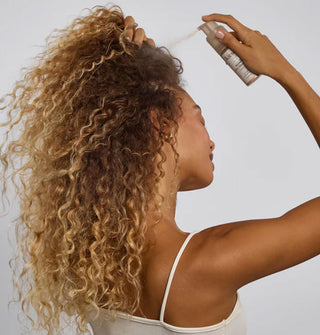 Model dispenses a puff of Kitsch Volumizing Dry Shampoo onto roots
