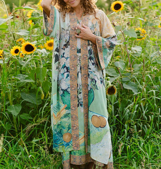 Model standing in a sunflower field wears a robe designed with elements of Vincent van Gogh's paintings