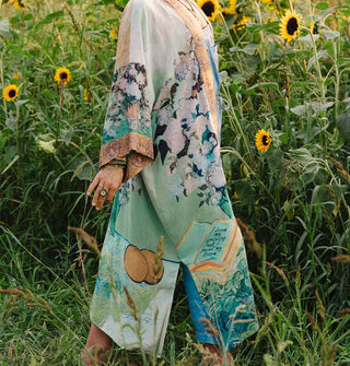 Model standing in a sunflower field wears a robe designed with elements of Vincent van Gogh's paintings