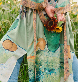 Model holding sunflowers wears a robe designed with elements of Vincent van Gogh's paintings