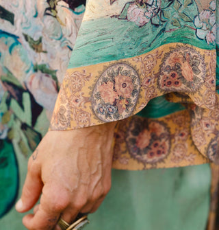 Closeup on the sleeve of a garment featuring elements of Vincent van Gogh's paintings with a contrasting cuff print