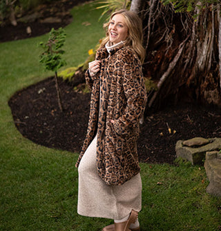 Smiling model wears a jaguar print faux fur coat with collar