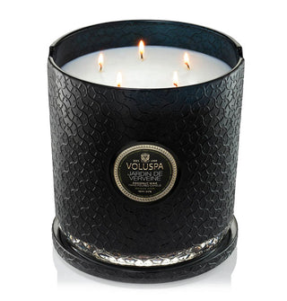 Lit five-wick Jardin de Verveine Voluspa candle in textural black glass vessel with lid removed and placed underneath as a coaster