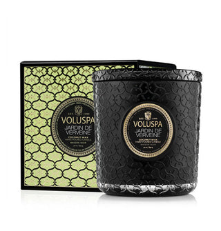 Textured black glass Jardin de Verveine Voluspa candle jar with matching lid is positioned next to its metallic gold and black lattice-patterned gift box