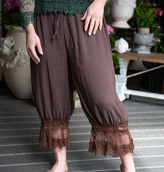 Model wears a pair of brown pantaloons with lace trim and a waist tie