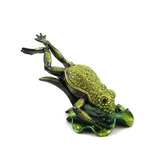 A trinket box designed to resemble a frog leaping onto a lily pad is adorned with green crystals across the frog's head and body