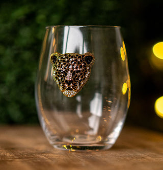 Clear stemless wine glass features a leopard's face with black and gold patterning accented by clear rhinestones