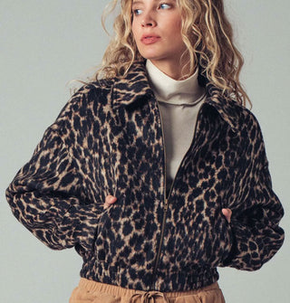 Model wears a zip-front collared leopard print jacket with pockets and an elastic waist