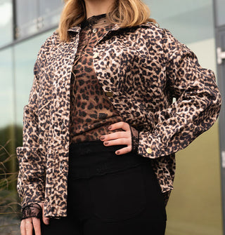 Model wears an open button-down leopard print jacket with a button-down leopard print cardigan and black pants
