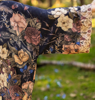 Sleeve of a kimono-style robe featuring lush floral designs and a contrasting cuff border print