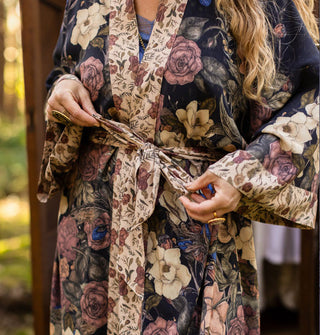 Model ties the belt of a kimono-style robe with contrasting floral prints