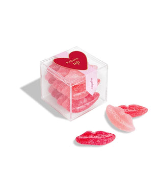 Clear cube of sugared dark and light pink Sugarfina gummy lips candies with a red "Pucker Up" heart tag on the top
