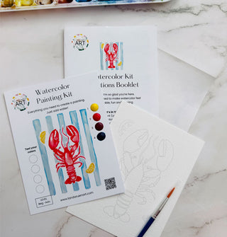 Components of a Lobster Watercolor Painting Kit on a marble tabletop with paint palette