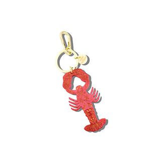 Red acetate lobster charm hangs from a gold keyring with round gold tab and lobster clasp attached