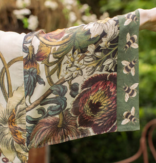 The sleeve of a loose-fitting, kimono-style robe with floral design contrasted by bumblebee print cuff