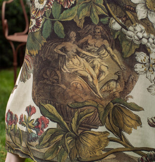 Closeup of an urn engraved with two figures and surrounded by flowers on the skirt of a long kimono-style robe