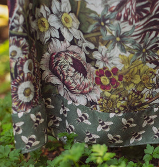 Closeup of floral pattern on a dress skirt with contrasting bee print trim