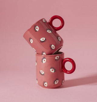 Two pink and red heart eyes mugs stacked one on top of the other