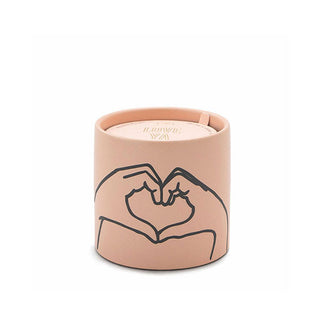 Terracotta pink ceramic candle jar features a painted black line drawing of two hands pressed together to form a heart shape