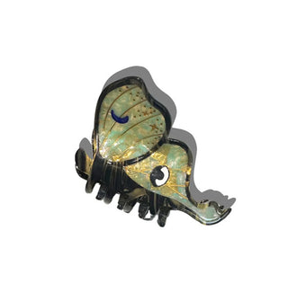 Green and gold hair clip designed to resemble a luna moth features crescent moon and eye accents and a dark border