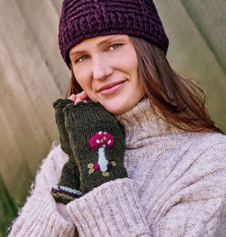 Model wears a pair of dark green fingerless gloves with embroidered mushroom design