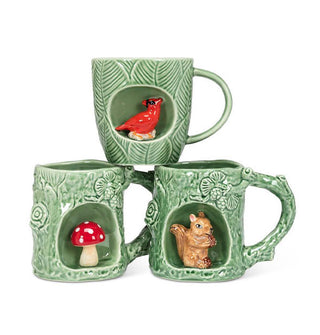 Three green textured mugs, each with an alcove featuring red cardinal, amanita mushroom, and brown squirrel respectively