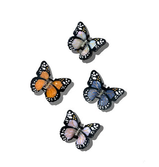Four monarch butterfly hair clips in orange, silver, blue, and pink with black and white accents