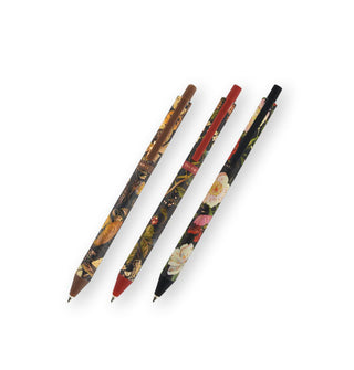 Set of three click-top ballpoint pens with floral patterns on dark backgrounds accented by brown, red, and black respectively