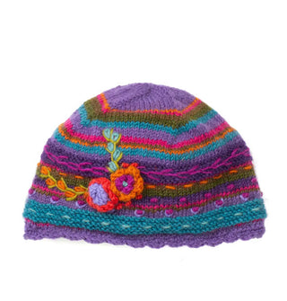 Purple, green, gold, blue, and pink striped beanie with a scalloped edge and textural flower and leaf details