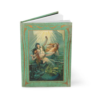 Slightly open journal features vintage cover illustration of three mermaids cavorting in the water under rays of sunlight inside a green border with gold accents