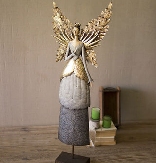 Angel figurine with gold wing, crown, and skirt details is mounted on a metallic block base