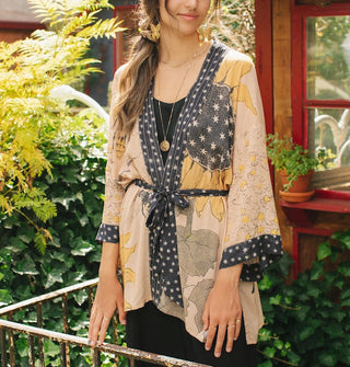 Model wears a kimono-style cardigan with sunflower motif and contrasting black and white print borders tied with a matching belt