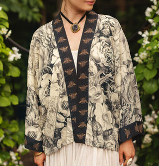 Model wears a cropped kimono-style cardigan with black and white floral print and contrasting bee print borders