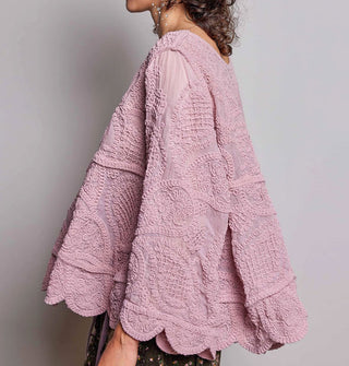 Model wears a dusty pink, oversized-fit, scalloped-edge crocheted blouse with paisley pattern