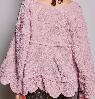 Model wears a dusty pink, oversized-fit, scalloped-edge crocheted blouse with paisley pattern