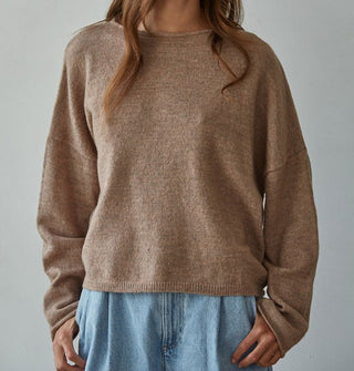 Model wears a slouchy brown sweater with rolled boat neckline